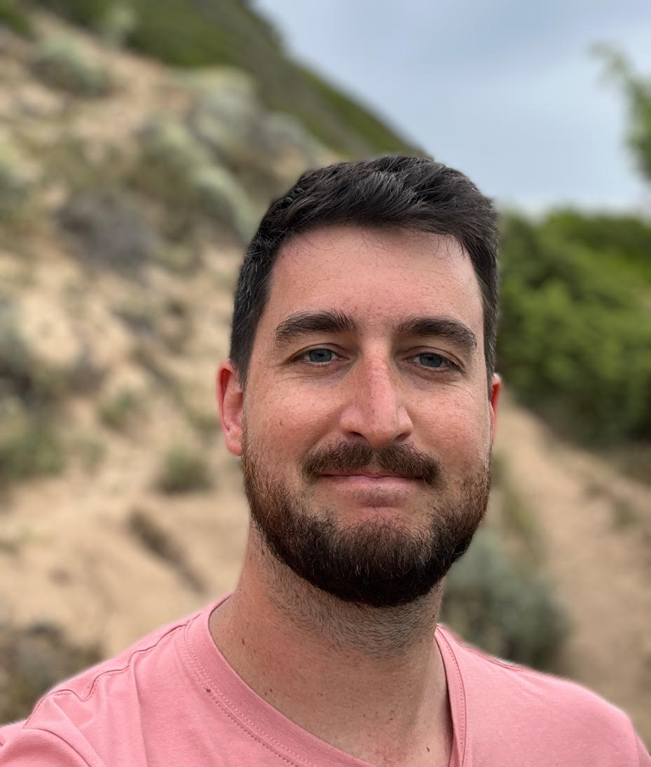 Photo of Robert Tinkle a man with dark brown hair and freckles.