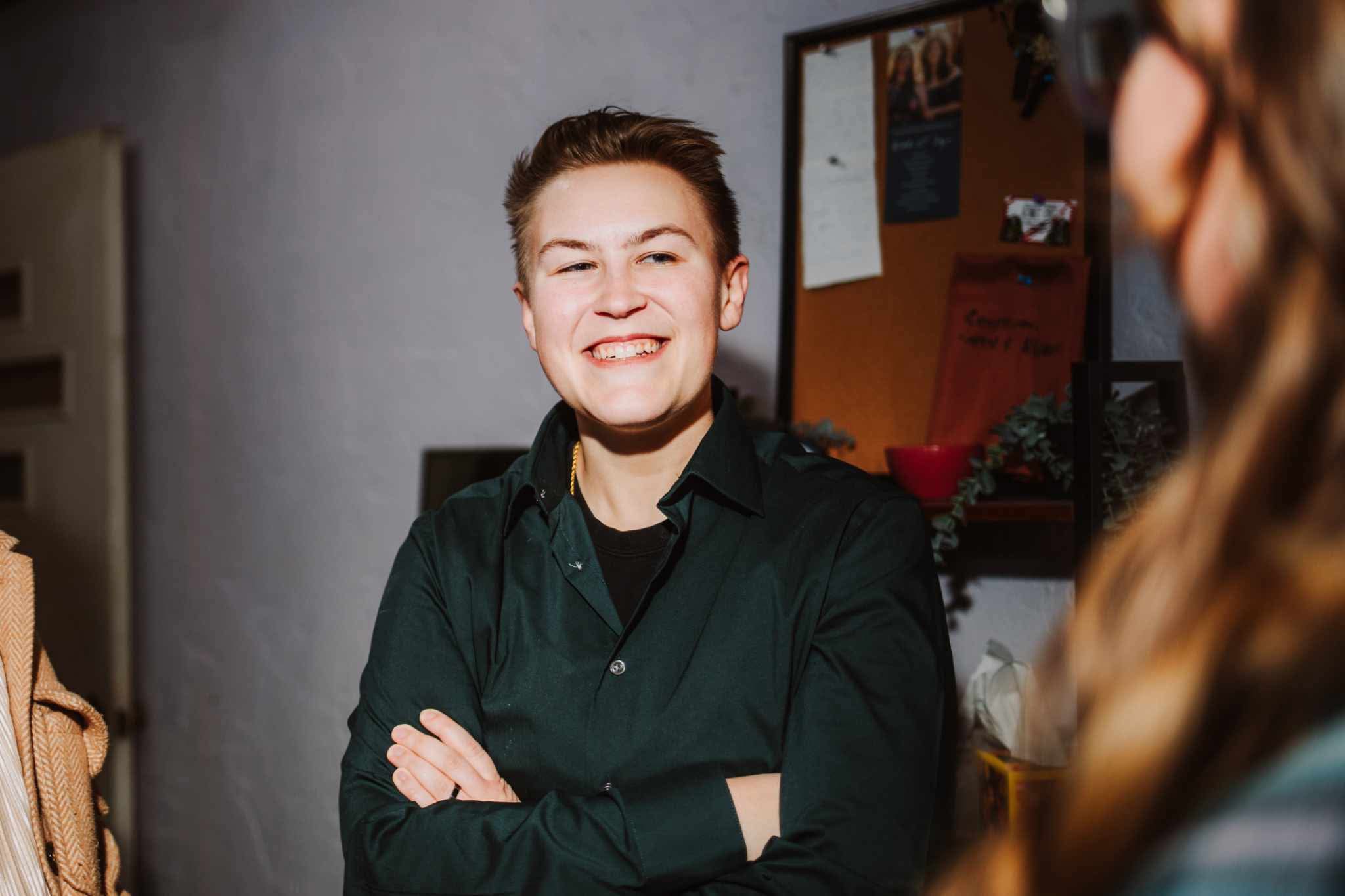 HM-Headshot photo of Haley Mullins. a person with short brown hair smiling with a black shirt on.