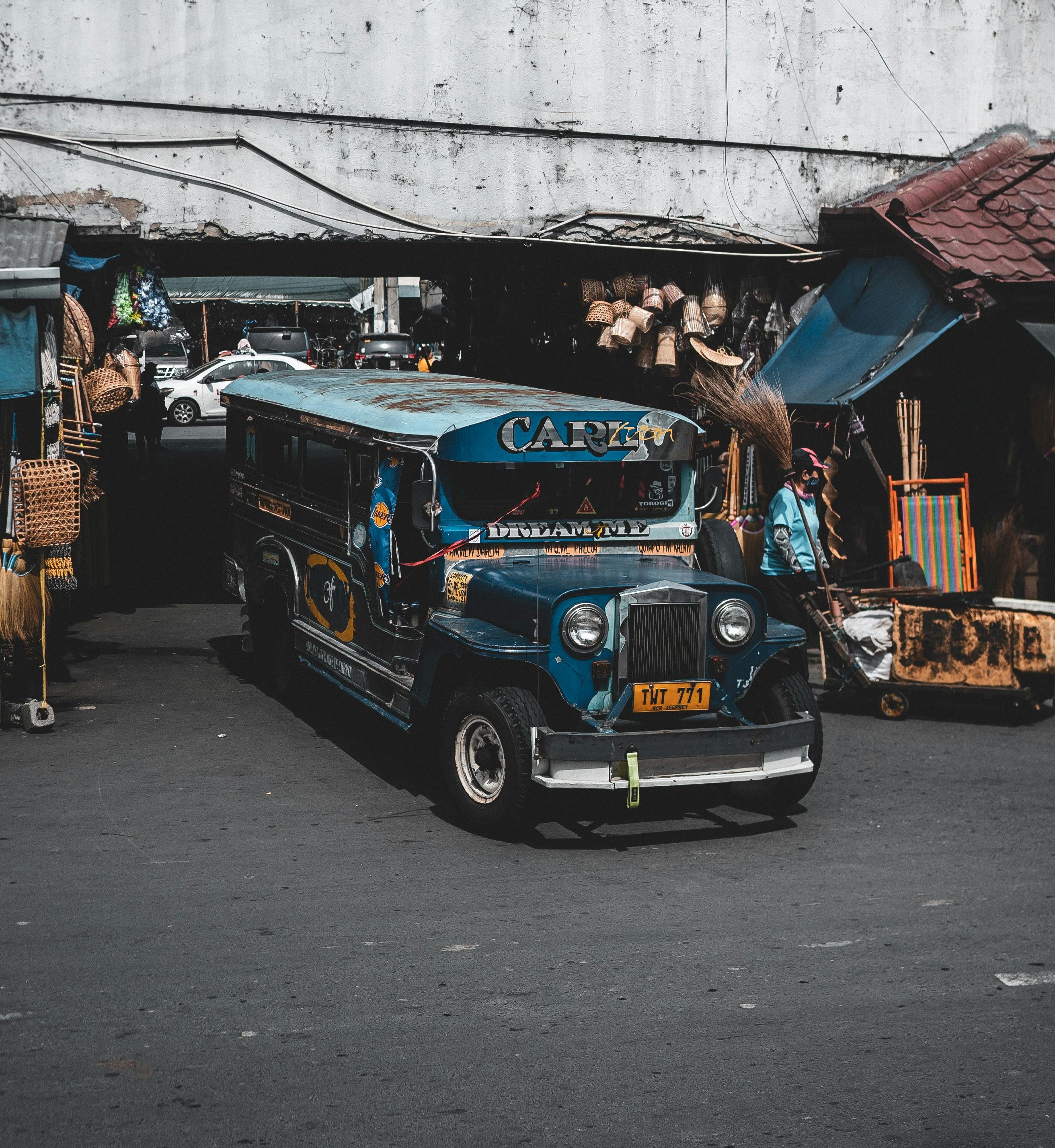a photo of a blue 'jeepney' bus on a crowded road